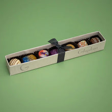 Load image into Gallery viewer, Elegant white box of assorted Ghyslain chocolates with black ribbon on green background