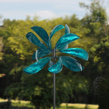 Load image into Gallery viewer, Turquoise blue metal wind spinner with curved petal blades on tall pole in garden setting