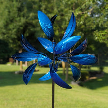 Load image into Gallery viewer, Blue metallic wind spinner with curved petals mounted on pole in garden setting