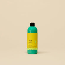 Load image into Gallery viewer, Green and yellow plant food fertilizer bottle with black cap on neutral background