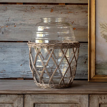 Load image into Gallery viewer, Large clear glass jar with woven rattan basket holder on rustic wooden surface