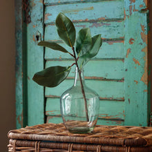 Load image into Gallery viewer, Southern Magnolia branch with glossy dark green leaves displayed in a clear glass demijohn vase