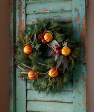 Load image into Gallery viewer, Southern Colonial Christmas wreath with dried oranges, red berries, and pine branches on rustic door