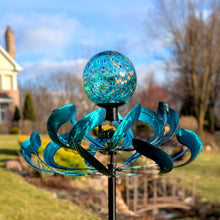 Load image into Gallery viewer, Turquoise metal wind spinner with decorative orb top mounted on black pole in garden setting