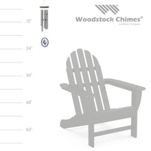 Load image into Gallery viewer, Woodstock wind chime with silver tubes and colorful flower medallion shown with size comparison to Adirondack chair
