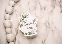Load image into Gallery viewer, Plant Lady vinyl sticker with botanical leaf design on marble surface with wooden beads
