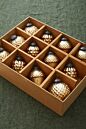 Load image into Gallery viewer, Gold and cream textured Christmas ornaments arranged in wooden grid display box