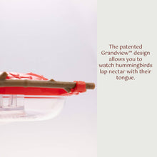 Load image into Gallery viewer, Red hummingbird feeder with clear viewing chamber showing nectar level and feeding ports