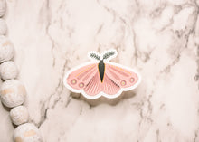 Load image into Gallery viewer, Rose-colored butterfly vinyl sticker with feathered antennae on marble surface with decorative stones