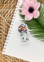 Load image into Gallery viewer, Clear vinyl sticker featuring mason jar with colorful flowers and bees on spiral notebook