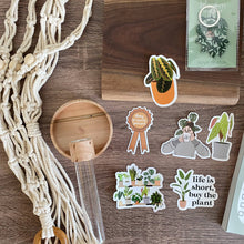 Load image into Gallery viewer, Plant-themed stickers including 'Life is short, buy the plant' motto on wooden surface with macrame