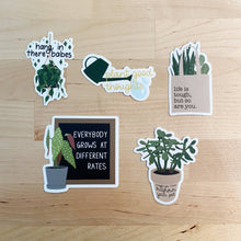 Load image into Gallery viewer, Five plant-themed motivational stickers with encouraging quotes and houseplant illustrations on wood surface