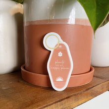 Load image into Gallery viewer, Coral pink motel keychain sticker with 'plants are my happy place' text against terracotta plant pot