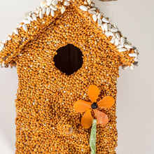 Load image into Gallery viewer, Decorative bird house covered in orange lentils with white bean roof trim and orange flower decoration