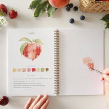 Load image into Gallery viewer, Open watercolor workbook showing peach painting tutorial with color palette and instructions