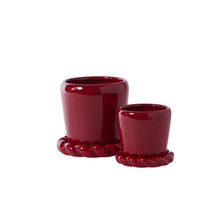 Load image into Gallery viewer, Set of two glossy deep red ceramic planters with braided rope-style saucers in small and large sizes.