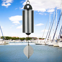 Load image into Gallery viewer, Antique silver wind chime with leaf-shaped sail hanging over marina with sailboats