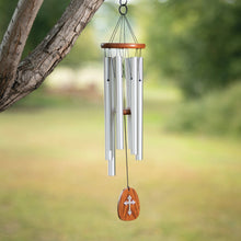Load image into Gallery viewer, Medium wind chime with silver tubes and wooden cross pendant hanging from tree branch