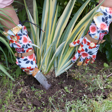 Load image into Gallery viewer, Floral patterned arm-length gardening gloves being worn while using hand trowel near spiky plant