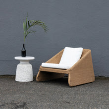 Load image into Gallery viewer, Brown wicker outdoor chair with white cushions next to decorative side table