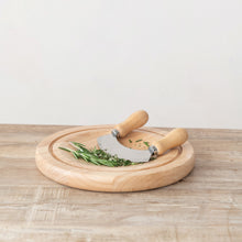 Load image into Gallery viewer, Round wooden cutting board with curved herb chopping knife and fresh rosemary herbs