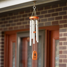Load image into Gallery viewer, Woodstock wind chime with silver tubes and wooden paw print pendant hanging outdoors