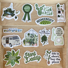 Load image into Gallery viewer, Collection of plant-themed vinyl stickers with sayings like Plant Daddy and Plant Parent on wooden surface