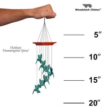 Load image into Gallery viewer, Hand holding Woodstock Chimes hummingbird spiral wind chime with green verdigris birds and measurement scale
