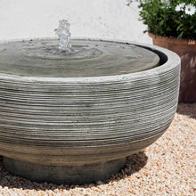 Load image into Gallery viewer, Modern ribbed concrete water fountain with central spout on pebbled garden surface