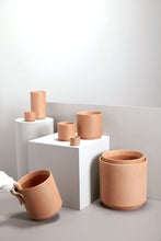 Load image into Gallery viewer, Collection of terracotta Kendall pots in various sizes displayed on white pedestals