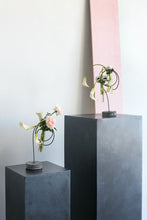 Load image into Gallery viewer, Modern black metal flower stands with circular hoops holding fresh flowers on concrete pedestals