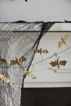 Load image into Gallery viewer, Gold paper bat garland draped over white fireplace mantel with black mesh netting